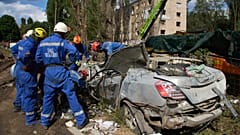 FILE: Emergency workers inspect a damaged car close to the multi-storey residential house struck by a Russian missile killing 31 civilians, in Kyiv, 1 August 2025