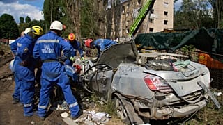 FILE: Emergency workers inspect a damaged car close to the multi-storey residential house struck by a Russian missile killing 31 civilians, in Kyiv, 1 August 2025