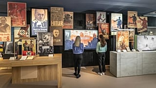 Two visitors look at an exhibit inside the Imperial War Museum. 