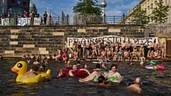 İnsanlar, 12 Ağustos 2025 Salı günü, Berlin, Almanya'da Spree Nehri'nde yüzerek nehirde yüzme yasağının kaldırılmasını talep ettiler.