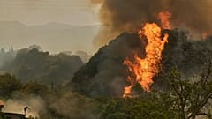 Un homme lutte contre le feu alors qu'il s'approche d'une maison lors d'un incendie de forêt à Vounteni, dans la banlieue de Patras, dans l'ouest de la Grèce, mercredi 13 août 2025. 