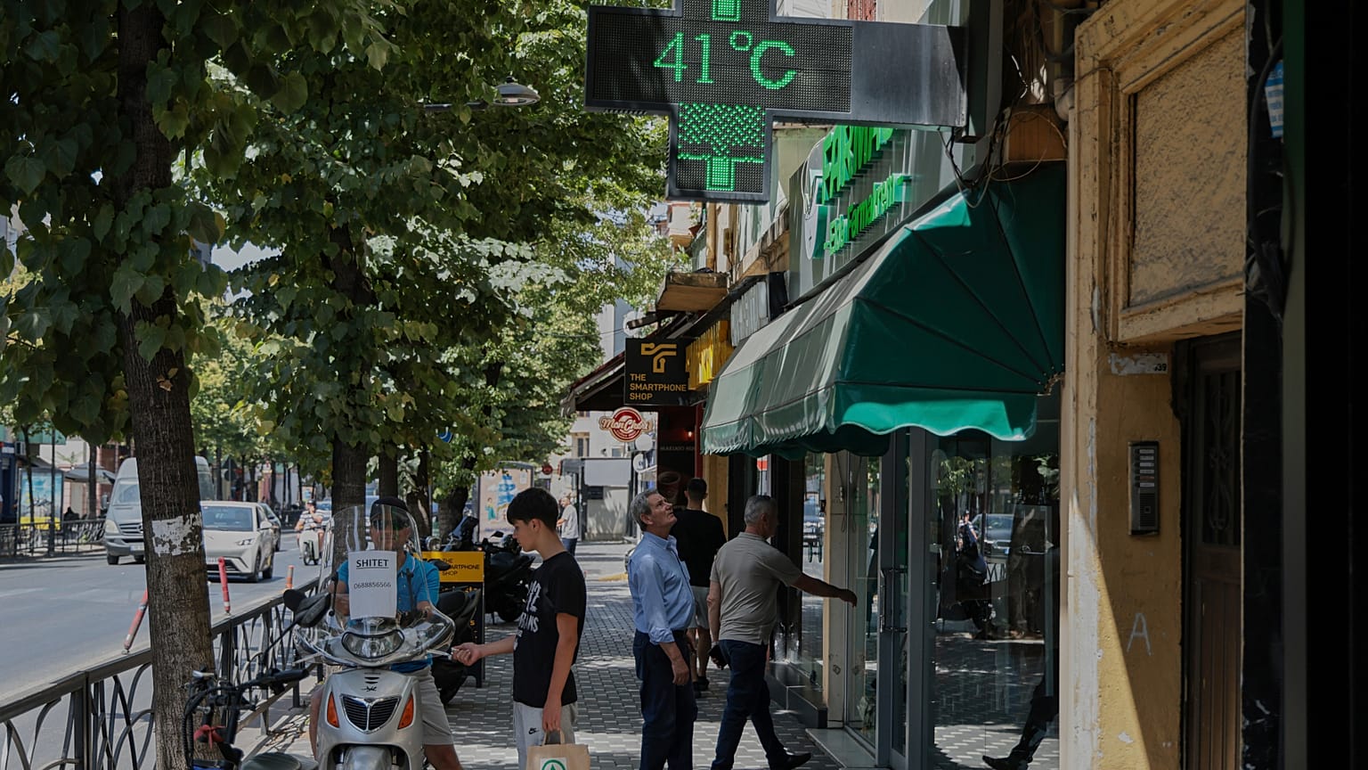 A man looks at a thermometer of a farmacy reading 41 degrees Celsius in Tirana, Albania.
