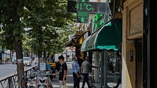 A man looks at a thermometer of a farmacy reading 41 degrees Celsius in Tirana, Albania.