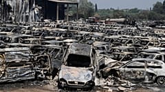 13 Ağustos 2025 Çarşamba günü Batı Yunanistan'da Patras kenti yakınlarında çıkan bir yangın sırasında Kato Achaia'daki bir otoparkta yanmış arabalar görülüyor.