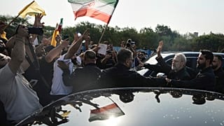 رئيس المجلس الأعلى للأمن القومي الإيراني علي لاريجاني يحيي أنصار حزب الله الذين تجمعوا للترحيب به خارج مطار رفيق الحريري الدولي في بيروت، لبنان، الأربعاء 13 أغسطس/ آب 2025.