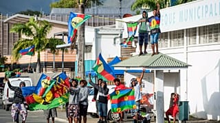 Independence supporters demonstrate with the Kanak flag outside a voting station in the Riviere Salee district of Noumea, 4 October, 2020