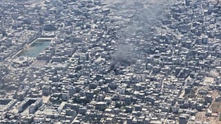 Fumo na cidade de Gaza visto de um avião C-130 da Força Aérea jordana durante um lançamento aéreo de ajuda humanitária aos palestinianos, 7 de agosto de 2025