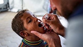 عامل صحي يعطي لقاح شلل الأطفال لطفل في مستشفى في دير البلح، وسط قطاع غزة، الأحد 1 سبتمبر/ أيلول 2024.