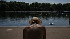 Ein Mann sitzt in einem Park in London in der Sonne, während Teile des Vereinigten Königreichs im August 2025 von einer Hitzewelle heimgesucht werden.