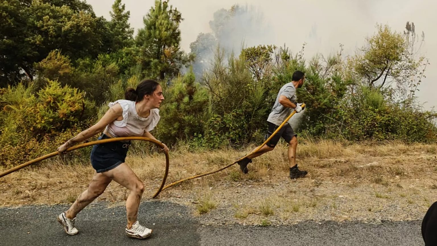 Residentes y voluntarios ayudan a sofocar las llamas en el incendio de Larouco el 13 de agosto de 2025.