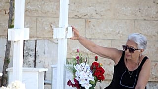 FILE: A woman touches the photo at the grave of her relative, killed in the 1974 Turkish invasion of Cyprus, in Nicosia, 20 July 2024