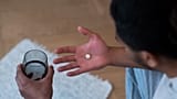 Un uomo si prepara a prendere le medicine.