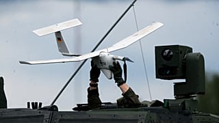 Ein Soldat hält eine Drohne auf einem NATO-Militärfahrzeug, das während einer militärischen Übung auf dem Truppenübungsplatz in Pabrade, etwa 60 km nördlich der Hauptstadt Vilnius, rollt.