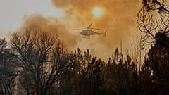Un hélicoptère largue de l'eau sur un feu de forêt à Larouco, au nord-ouest de l'Espagne, le 13 août 2025. 
