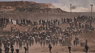 فلسطينيون يحملون طرود مساعدات إنسانية بالقرب من مركز توزيع مؤسسة غزة الإنسانية الذي تديره المنظمة المدعومة من الولايات المتحدة، في نتساريم، وسط قطاع غزة