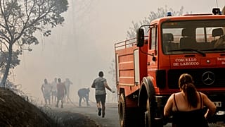 Firefighters and a local residents try to put out a forest fire in Larouco, northwestern Spain, Wednesday, Aug. 13, 2025.