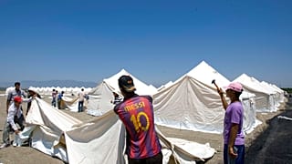  عمال الهلال الأحمر التركي ينصبون الخيام في مخيم جديد للاجئين السوريين المحتملين في بلدة أبايدين التركية في محافظة هاتاي، تركيا، الجمعة 24 يونيو/حزيران 2011.