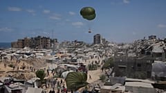 Varios palestinos corren para alcanzar la ayuda humanitaria lanzada por aire en la Ciudad de Gaza, el 7 de agosto de 2025.