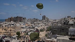 Varios palestinos corren para alcanzar la ayuda humanitaria lanzada por aire en la Ciudad de Gaza, el 7 de agosto de 2025.