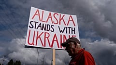 Dug Loshbaugh hält ein Schild während einer Kundgebung in Anchorage, Alaska, am Donnerstag, den 14. August 2025, vor einem Treffen zwischen Präsident Donald Trump und dem russischen Präsidenten Wladimir Putin.