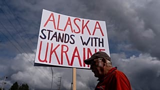 Dug Loshbaugh sostiene un cartel durante una manifestación en Anchorage, Alaska, el jueves 14 de agosto de 2025, antes de una reunión entre el presidente Donald Trump y el presidente ruso Vladimir Putin