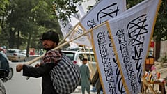 Un hombre vende banderas talibanes antes de las celebraciones del cuarto aniversario de la retirada de la OTAN y Estados Unidos de Afganistán en Kabul, 14 de agosto de 2025.