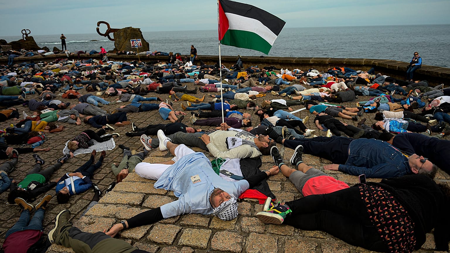 متظاهرون مؤيدون للفلسطينيين يستلقون على الأرض احتجاجًا على الهجمات الإسرائيلية على غزة، في سان سيباستيان، شمال إسبانيا، يوم الأحد 17 مارس 2024