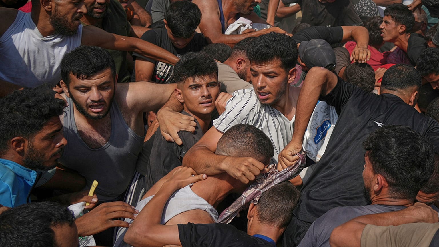 فلسطينيون يحاولون جمع مساعدات إنسانية أُسقطت بالمظلات فوق مدينة غزة، شمال القطاع، 14 أغسطس 2025.
