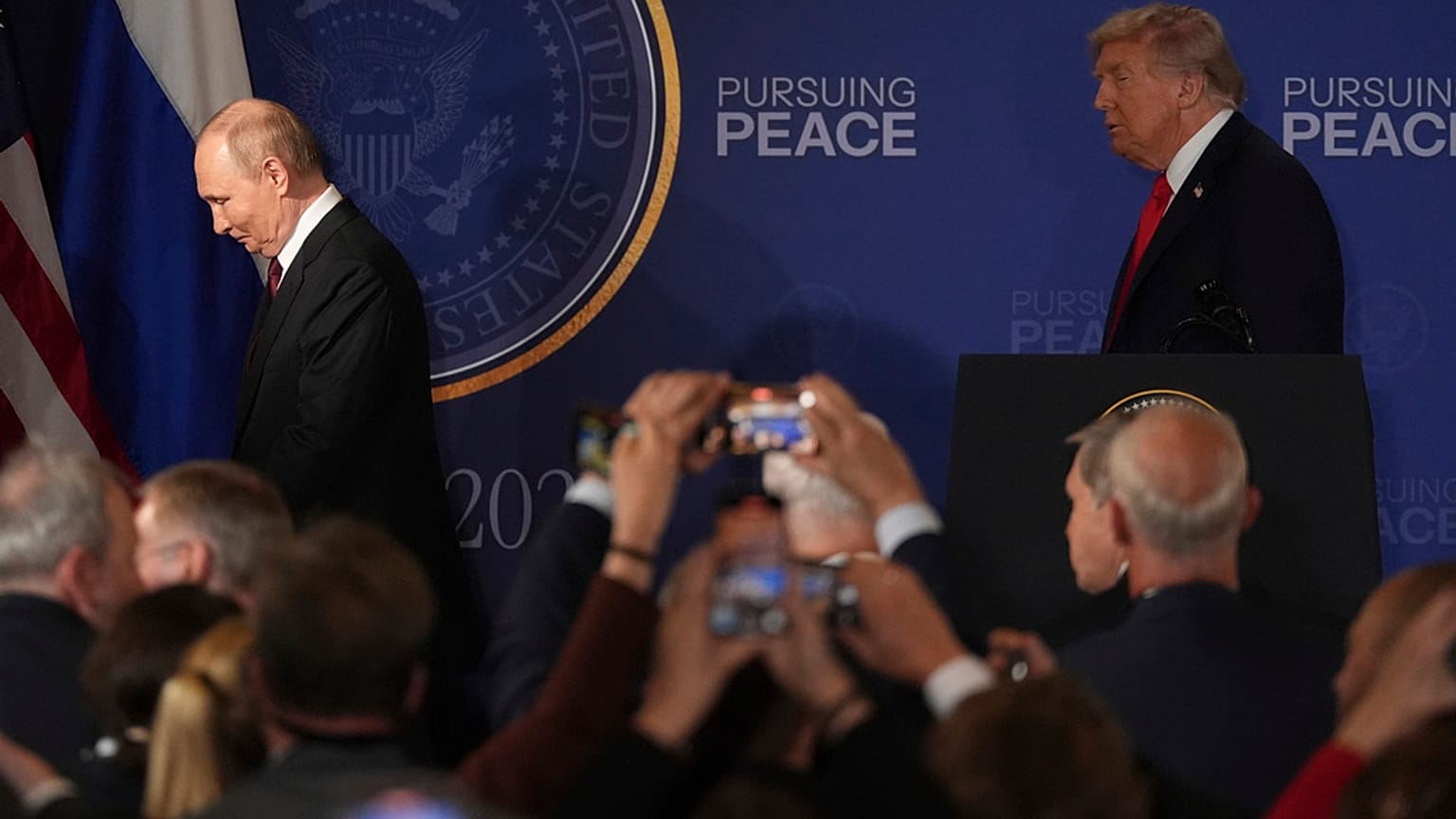 O Presidente Donald Trump, à direita, e o Presidente russo Vladimir Putin afastam-se após uma conferência de imprensa conjunta na Base Conjunta Elmendorf-Richardson, no Alasca