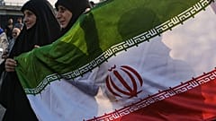 أنصار حزب الله يحملون العلم الإيراني أثناء تجمعهم للترحيب بعلي لاريجاني خارج مطار رفيق الحريري الدولي في بيروت، لبنان، الأربعاء 13 أغسطس/ آب 2025.