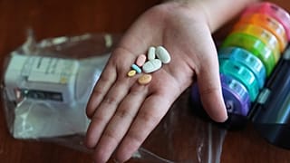 Una persona se prepara para tomar su medicación