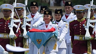 حامل پرچم بیانکا آلسیا کریستابلا لانتانگ، در مرکز، یک پرچم اندونزی را بر روی سینی حمل می کند تا در مراسمی که به مناسبت روز برگزار می شود، تکان داده می شود
