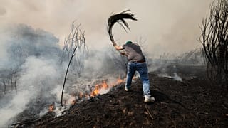 Ένας άνδρας πολεμά μια πυρκαγιά στην Veiga das Meas, βορειοδυτική Ισπανία, Σάββατο, 16 Αυγούστου 2025. 