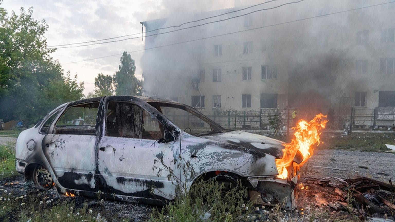 A car burns against the background of a damaged residential building following Russia's missile attack in Kharkiv, Ukraine, Monday, Aug. 18, 2025