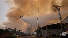 Bir yangın söndürme uçağı, 16 Ağustos 2025 Cumartesi günü İspanya'nın kuzeybatısındaki Veiga das Meas'ta bir orman yangınına su döküyor