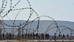 Migrants rescued south of Crete walk after their arrival at the port of Lavrio, 10 July, 2025