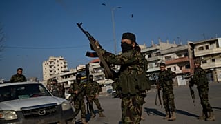 أحد عناصر قوات الأمن الجديدة يطلق النار في الهواء في مدينة حمص السورية، الجمعة 3 كانون الثاني/يناير 2025.