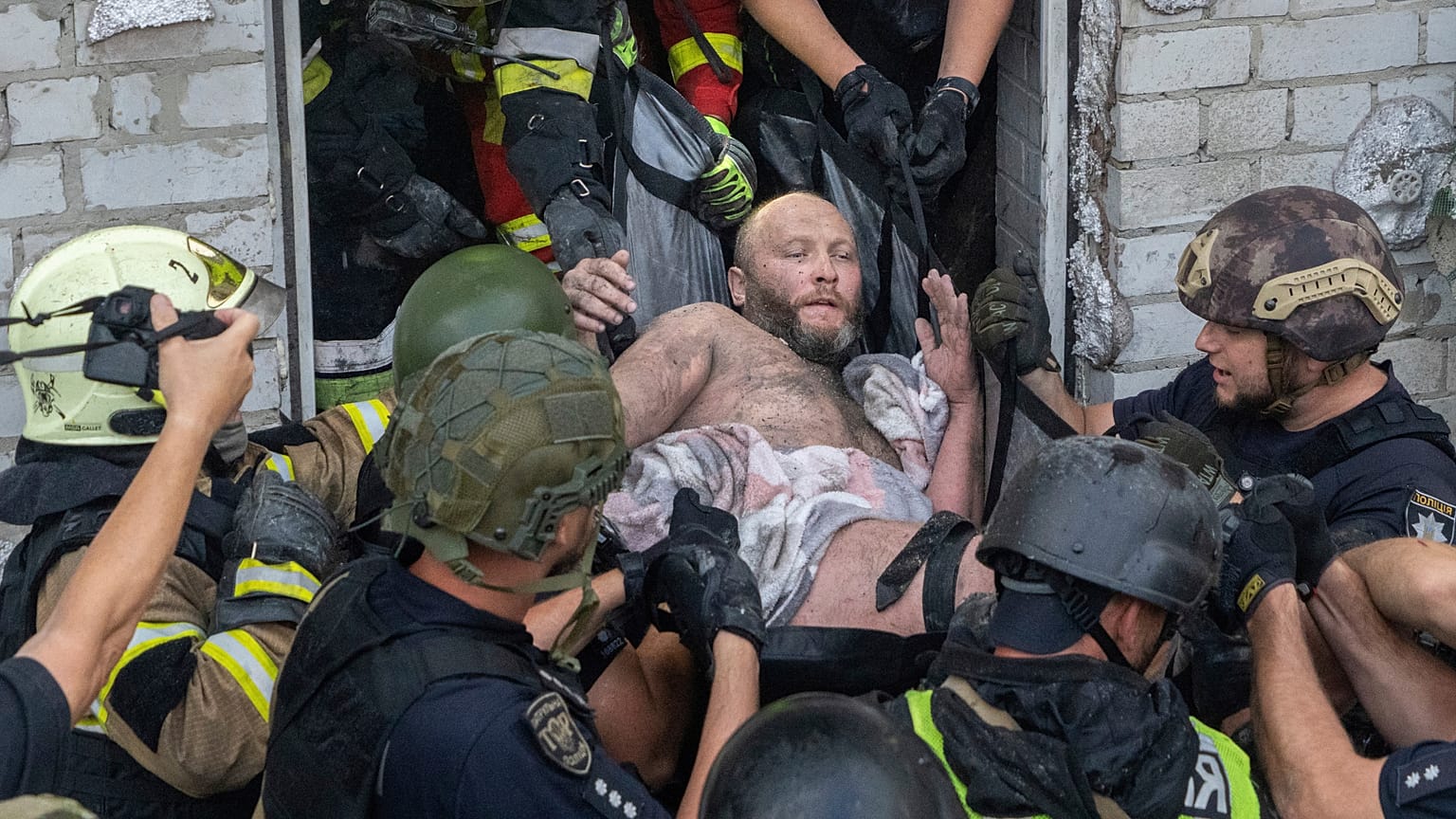 Equipes de resgate evacuam um civil ferido após um edifício residencial ser atingido por um ataque de mísseis russos em Kharkiv, Ucrânia, segunda-feira, 18 de agosto de 2025