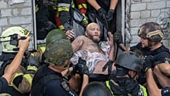 Des secouristes évacuent un civil blessé après qu'un immeuble résidentiel a été touché par une attaque de missiles russes à Kharkiv, en Ukraine, lundi 18 août 2025.