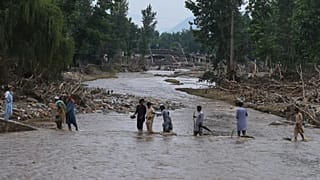 Residentes locales cruzan un arroyo tras la inundación repentina del viernes en el pueblo de Pishoreen, en el distrito de Buner, en el noroeste de Pakistán.