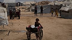 فتاة فلسطينية تدفع عربة محمّلة بالمياه في خان يونس، جنوب غزة، 13 أغسطس 2025.
