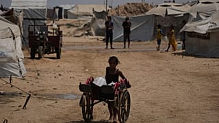 فتاة فلسطينية تدفع عربة محمّلة بالمياه في خان يونس، جنوب غزة، 13 أغسطس 2025.