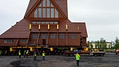 Bauarbeiter und Medienvertreter stehen in der Nähe der Kiruna-Kirche, einer schwedisch-lutherischen Holzkirche im samischen Stil in Kiruna, Schweden, 18. August 2025