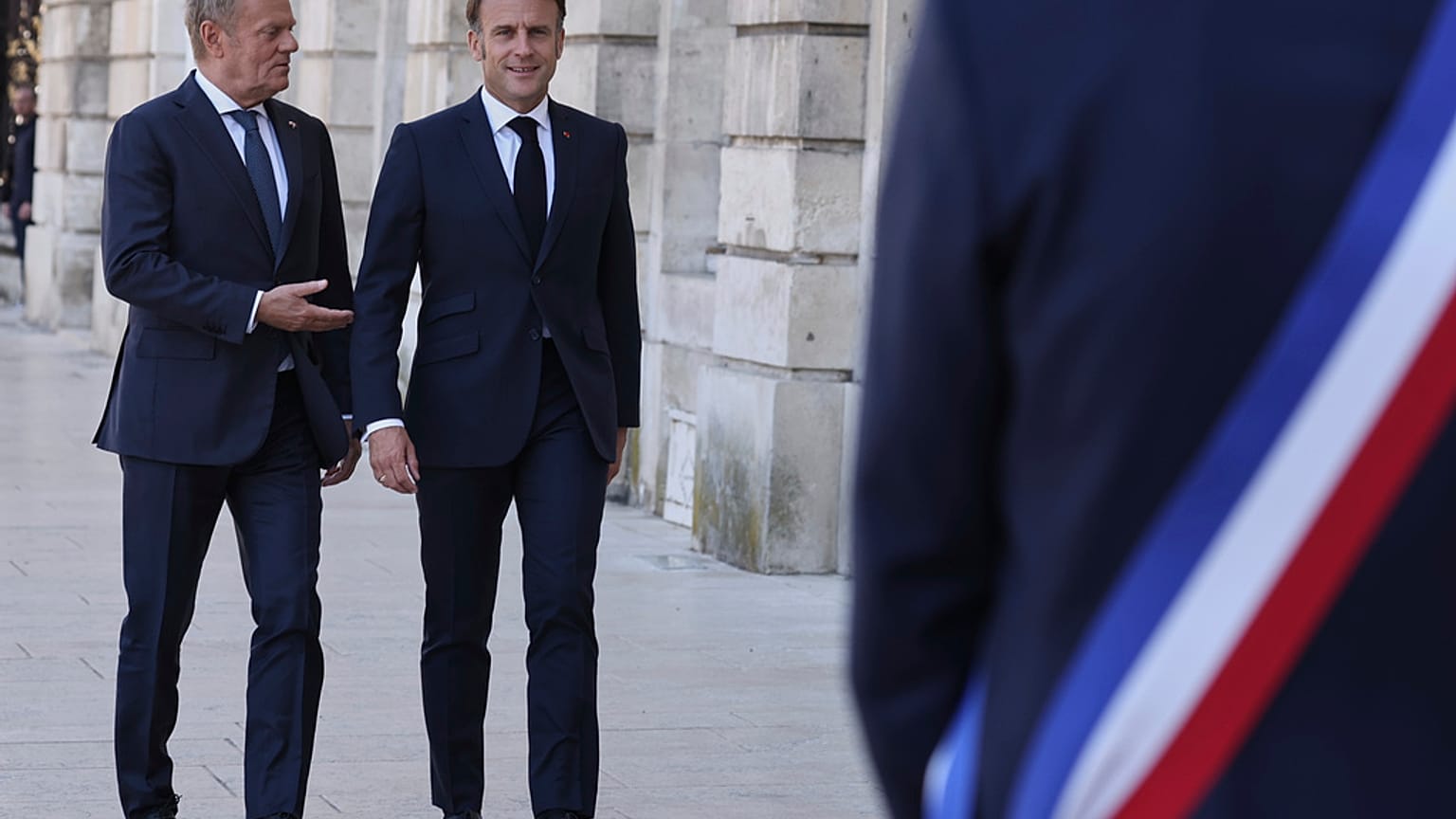 Premier Polski Donald Tusk (po lewej) i prezydent Francji Emmanuel Macron przybywają do ratusza na rozmowy dwustronne.