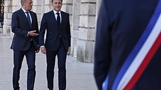 Premier Polski Donald Tusk (po lewej) i prezydent Francji Emmanuel Macron przybywają do ratusza na rozmowy dwustronne.