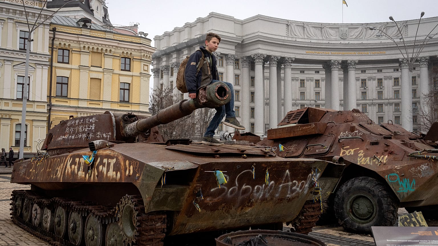Un garçon est assis sur un char russe endommagé dans le centre de Kiev, en Ukraine. Mars 2025.