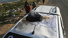 فلسطينيون يتفقدون مركبة تحمل شعار مطبخ العالم المركزي دمرها قصف إسرائيلي في دير البلح بقطاع غزة، الثلاثاء 2 أبريل/ نيسان 2024.