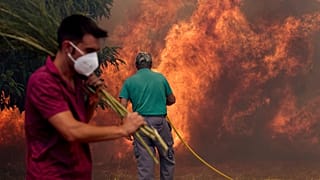 Residents battle a fire advancing toward Rebordondo village, near Ourense, in northwestern Spain, on Monday, Aug. 18, 2025