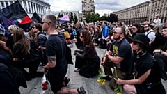 Menschen stehen auf den Knien während der Abschiedszeremonie von David Chichkan, einem ukrainischen Soldaten und Künstler, auf dem Unabhängigkeitsplatz in Kiew, Ukraine, am Montag, 18. August 2025
