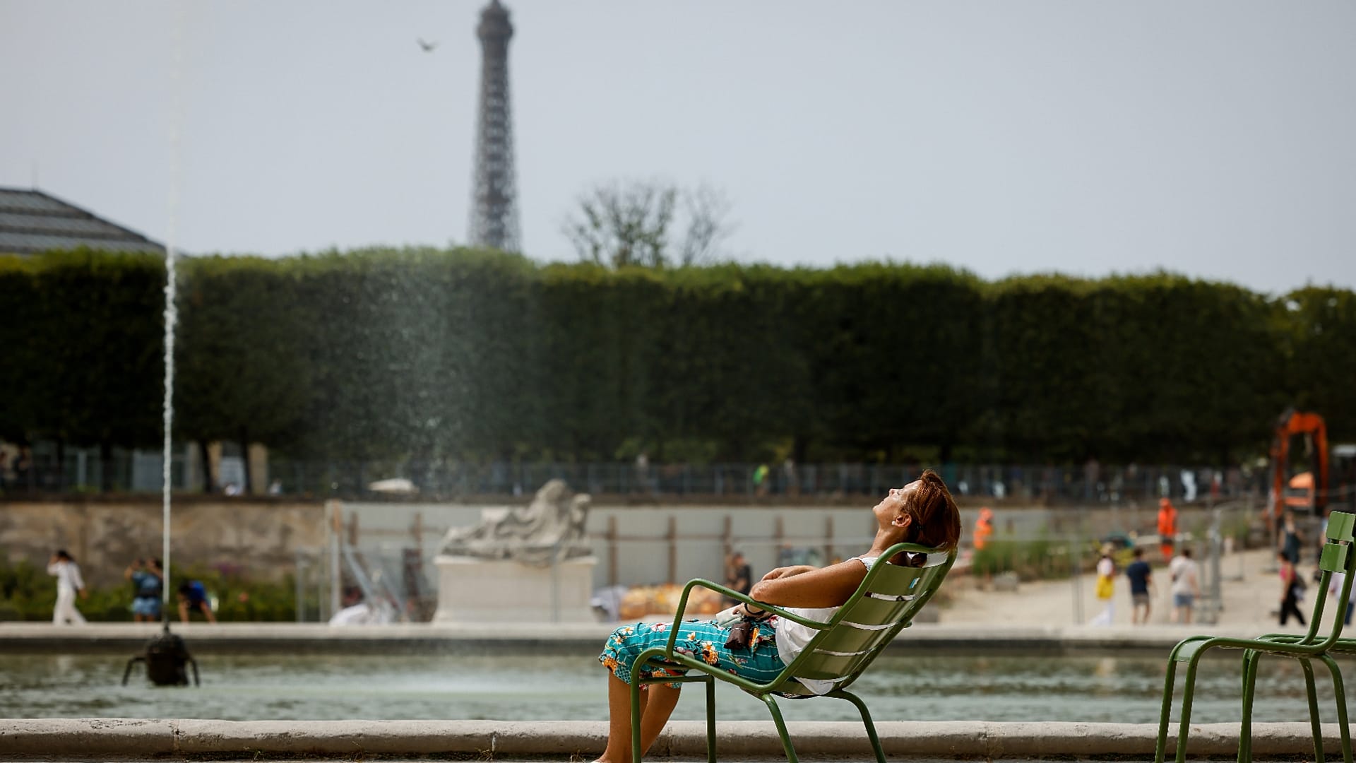 Una mujer disfruta del sol en los jardines de las Tullerías, en París.
